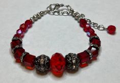 Beautiful red crystal glass beads paired up with metal beads with rhinestones  Measures 7.25" long with a 2" extension. Will be sent to you in a gift box. Strings are reenforced with end enforcers for less chance of breaking from wear. Adjustable Red Bracelet With Rhinestones, Adjustable Red Crystal Bracelet, Adjustable Red Crystal Bracelets, Metal Crystal Bracelet With Faceted Beads, Silver Beaded Bracelets With Bling For Gifts, Crystal Bracelets With Silver Beads As A Gift, Red Crystal Bracelet With Rhinestones For Party, Red Crystal Rhinestone Bracelet For Party, Red Rhinestone Crystal Bracelet For Party