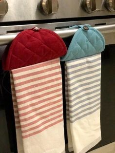 three towels hanging from the handle of an oven