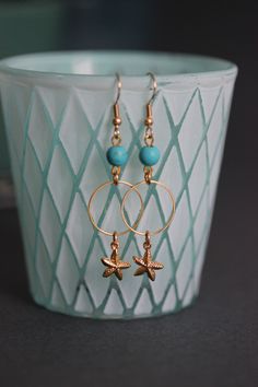 Lovely earrings with natural turquoise stone 6 mm beads, gold tone hoops, seafish charms and gold tone earring hooks. Earring hooks are from nickel free and lead free metal. Perfect for everyday wear! *The total lenght of earrings is about 59 mm including the earring hooks. Other earrings of my shop you can see here: https://www.etsy.com/shop/NaTavelli?section_id=13757927 Thanks for visit. Gold Earrings For Beach, Gold Dangle Earrings For Beach, Ocean-inspired Gold Jewelry With Ear Wire, Gold Pierced Hoop Earrings For Beach, Gold Metal Hoop Earrings For Beach, Ocean-inspired Gold Wire Wrapped Jewelry, Gold Jewelry With Starfish Charm, Gold Earrings With Starfish Charm For Beach, Gold Metal Jewelry With Starfish Charm