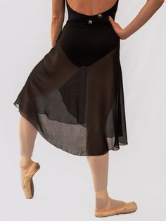 a woman in a black dress is standing with her back to the camera and wearing ballet shoes