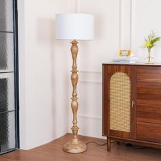 a lamp on a table next to a dresser