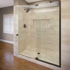 an empty bathroom with a walk in shower and wooden flooring, along with hard wood floors