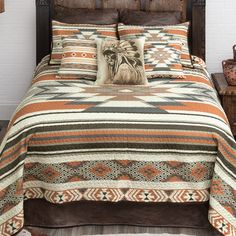 a bed with an orange and brown bedspread on top of it next to two nightstands