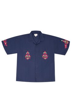 A dark blue cotton embroidered shirt featuring vibrant, plant-inspired embroidery reminiscent of A.R. Chughtai’s art on pockets and sleeves. Navy Embroidered Cotton Tops, Traditional Cotton Tops With Embroidered Cuffs, Relaxed Fit Cotton Camp Shirt With Floral Embroidery, Blue Embroidered Short Sleeve Shirt, Blue Shirt With Floral Embroidery And Relaxed Fit, Blue Floral Embroidered Shirt With Relaxed Fit, Blue Floral Embroidery Shirt With Relaxed Fit, Short Sleeve Shirt With Multicolor Floral Embroidery, Indigo Cotton Top With Floral Embroidery