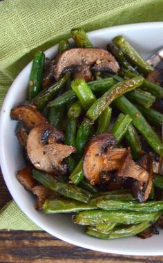 a white bowl filled with green beans and mushrooms