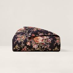 a black floral bag with pink flowers on it