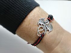 Dragon charm bracelet/ Essential oil bracelet/ fantasy bracelet/ Dragon Diffuser bracelet/ Aroma theraphy bracelet/ Macrame bracelet/ Animal charm bracelet/ Dragon lava bracelet/ Dragon adjustable bracelet/ friendship bracelet/ red and black dragon bracelet. This listing is for one (1) bracelet only This bracelet is nicely placed in a gift bags size (9x7cm).. This fantasy bracelet was made Chinese wax cord 1mm, with a Natural black lava stone 8mm beads, the dragon measures 34.5mm long 27.5mm wid Macrame Charm Bracelet, Handmade Silver Wristband As Gift, Silver Macrame Spiritual Bracelets, Handmade Spiritual Leather Bracelet As Gift, Handmade Spiritual Leather Bracelet For Gift, Silver Macrame Bracelets As Gift, Spiritual Macrame Bracelets As Gift, Silver Macrame Bracelets For Gift, Spiritual Macrame Bracelet As Gift