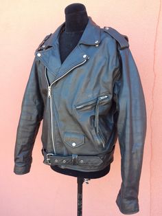 "Vintage secondhand unisex \"PLG\" (World Wide Putnam Leather Gold) black genuine leather double-breasted Brando biker-style heavy, well made motorcycle jacket with zippers, lots of pockets & belt. Nice black quilted lining. Inner pocket. Tag size 46 Underarm to underarm is 22\"ish Top back collar to bottom is 29\" Shoulder seam to end of sleeve is 26\" In very good overall used lightly shape. Missing in 1 zipper. Some minor scuffs & such." Black Moto Leather Jacket With Belt Loops, Biker Jacket With Belt Loops For Biker Events, Biker Jacket With Belt Loops, Long Sleeve Biker Jacket With Belt Loops, Black Moto Outerwear With Belt Loops, Winter Biker Jacket With Belt Loops, Classic Black Leather Jacket With Belt Loops, Classic Black Biker Jacket With Belt Loops, Pueblo Native Americans