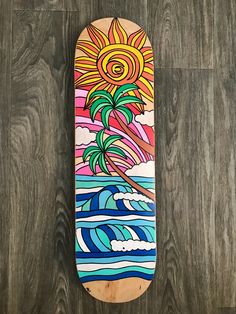 a skateboard with an image of a palm tree on the top and waves in the bottom