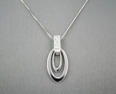 "14 KARAT WHITE GOLD MODERN PENDANT WITH HIGH POLISH . AVAILABLE SAME STYLE EARRINGS metal-14kwg weight-3.4gm FOR ADDITIONAL QUESTIONS ABOUT THIS PRODUCT: Please feel free to message us. We are quick to respond to all your inquiries. PLEASE choose as \"FAVORITE\" on the right so the item will be added to your favorites list and you may always revisit it. CUSTOM ORDERS: Please feel free to contact us if you could not find the piece you had in mind. We know how important it is to find the right je Modern White Gold Oval Pendant Jewelry, Modern Diamond Pendant Necklace With Polished Finish, Modern Polished Diamond Pendant Necklace, Modern White Gold Diamond Necklace With Polished Finish, Modern Oval Pendant Jewelry For Anniversary, Modern Silver Diamond Necklace With Polished Finish, Fine Jewelry In White Gold With Shiny Finish, Modern White Gold Necklace With Diamond Accents, Modern Sterling Silver Diamond Necklace In White Gold