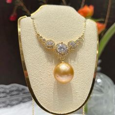 A stunning natural yellow pearl, carefully selected for its rich hue and radiant luster. Decorated this central gem is a halo of meticulously set zircon stones. It creates a luxurious and captivating effect, making this necklace a perfect statement piece for any high-end occasion like a gala, a sophisticated dinner, or an important celebration, this necklace promises to elevate your ensemble with its unmatched grandeur. Pearl Type: Freshwater Edison Pearls Pearl Quality: AAA [Shape]: Perfect Rou Gold Cubic Zirconia Pearl Necklace For Gift, Gold Pearl Necklace With Cubic Zirconia As Gift, High Luster Diamond Necklace For Anniversary, Elegant Pearl Necklace With Gemstone In Round Pendant, Elegant Pearl Necklace With Gemstone Round Pendant, Yellow Pearl Necklace As A Gift, Yellow Pearl Necklace As Gift, Yellow Round Pearl Necklace As A Gift, Formal Bridal Necklace With Pearl Pendant