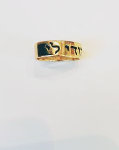 a gold ring with hebrew writing on it