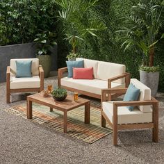 an outdoor living room with couches, tables and potted plants in the background