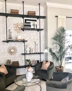 a living room with two couches and a coffee table in front of a white brick wall