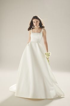 a woman in a white wedding dress holding a bouquet