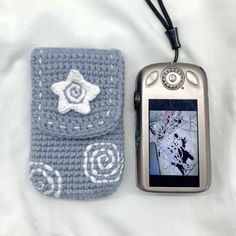 a cell phone with a crocheted case next to it