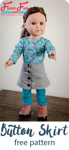 the doll is wearing a blue shirt and gray skirt with pink shoes, standing on a wooden table