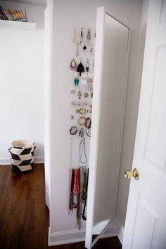 the door is open and there are many jewelry hanging on the wall in this room