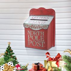 an old fashioned mailbox with christmas presents in front of it and other holiday decorations