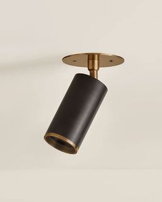 a black and gold ceiling light on a white wall