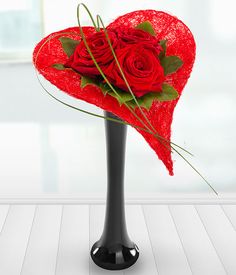 a black vase with red roses in it