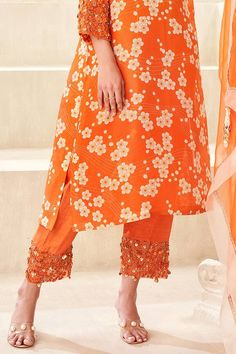 Orange kurta with floral print with pearl, thread and cutdana embroidery on the neckline and sleeves. Paired with an embroidered pant. - Aza Fashions Spring Chanderi Salwar Kameez With Printed Motifs, Chanderi Salwar Kameez With Printed Motifs For Spring, Spring Fitted Sharara With Gota Work, Fitted Spring Sharara With Gota Work, Spring Bollywood Cotton Silk Palazzo Set, Spring Bollywood Style Cotton Silk Palazzo Set, Wedding Bottoms With Dupatta For Eid, Spring Straight Kurta Set With Gota Work, Unstitched Bottoms With Zari Work For Wedding