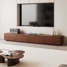 a flat screen tv mounted on the wall above a coffee table in a living room