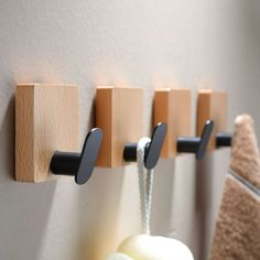 three wooden hooks are hanging on the wall