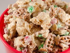 a red bowl filled with cereal salad on top of a table