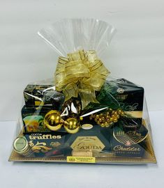 an assortment of chocolates and candy wrapped in cellophane with gold ribbon on top