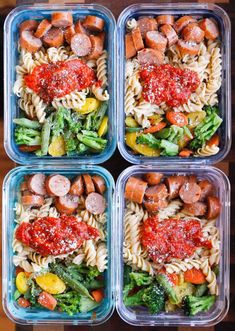 four plastic containers filled with different types of pasta and veggies in sauces