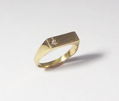 A 14k solid gold signet engagement ring with a diamond. This lovely minimal and clean designed signet ring is made of solid 14k gold and has a small diamond on one side (1.5 ct). The shiny diamond is set in a star designed inlay, which gives this ring yet more character and sparkle. This ring can be a great modern engagement ring or a high-class gift for any other happy occasion such as birthdays, births, anniversaries and more. This rin is great for everyday use - it is light and comfortable to Modern Signet Ring With Single Diamond, Minimalist Vvs Clarity Diamond Ring, Modern 14k Gold Jewelry With Single Diamond, Minimalist Diamond Signet Ring With Polished Finish, Modern White Gold Diamond Ring Stamped 14k, Minimalist Signet Ring With Single Cut Diamonds, Modern Gold Ring With Single Diamond, 14k Gold Diamond Ring With Polished Finish, Minimalist Diamond Rings With Polished Finish