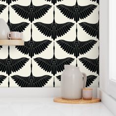 a black and white wallpaper with an abstract design in the middle, on a shelf next to a vase