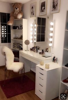 a white vanity with lights and a teddy bear