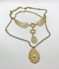 Lot of 2 super cool vintage mid-century gold tone necklaces, sold together only. First one is a fun collar necklace with an ornate circular geometric design. Original necklace was super short, so an extender has been added for adjustability. Hook closure, you can hook to where you like it. Approximately 18.25 inches maximum length. Second necklace has a vintage teardrop shaped medallion. Original clasp was degraded and replaced with a large lobster claw. Adjustable also. 24 inches length, pendan Antique Gold Choker Jewelry, Adjustable Gold Bib Choker Necklace, Ornate Gold-tone Metal Jewelry, Ornate Metal Choker Necklace, Gold Bib Choker Costume Jewelry, Bohemian Gold-tone Metal Jewelry, Gold Choker Bib Necklace As Costume Jewelry, Gold Vintage Bib Necklaces For Gifts, Vintage Gold Bib Necklace Gift