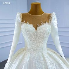 a white wedding dress with long sleeves on a mannequin