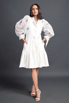 White dress, highlighted with floral confetti embroidery on puff sleeves.
Components: 1
Pattern: Placement Embroidery
Type Of Work: Floral Confetti
Neckline: Lapel Collar
Sleeve Type: Puff Sleeves
Fabric: Net
Color: White
Other Details: 
Side pockets
Frilled hem
Note: Belt worn by the model is not for sale
Occasion: Party - Aza Fashions White Dresses With Ruffles And Lantern Sleeves, White Lantern Sleeve Dress With Ruffles, Spring Dresses With Blouson Lantern Sleeves, White Puff Sleeve Dress With Ruffles, Embroidered Long Sleeve Organza Dress, White Midi Dress With Pleated Lantern Sleeves, White Midi Dress With Lantern Pleated Sleeves, Elegant Lantern Sleeve Dress With Floral Embroidery, White Lantern Sleeve Midi Dress For Party