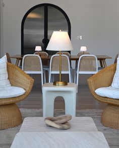 a living room filled with furniture and a lamp on top of a wooden floor next to a table