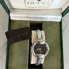 1400l - Silver, Stainless Steel Women's Quartz Watch With Black Face And "Gucci" Logo At 12 Marker/Back Clasp And Signature "Horsebit" Clasp Case Color: Silver Face Color: Black Dial Color: Silver Case Material: Stainless Steel Band Material: Stainless Steel **Brand New With Tags And Box** Gucci White Gold Watch With Polished Finish, Gucci White Gold Polished Watches, Modern Gucci Watch With Polished Finish, Gucci Silver Watch With Polished Finish, Classic Gucci Jewelry With Silver-tone Logo Plaque, Classic Gucci Watch With Polished Finish, Timeless Gucci Watch With Polished Finish, Gucci Timeless Watch With Polished Finish, Gucci Silver Jewelry With Silver-tone Logo Plaque