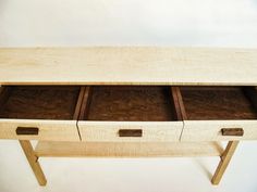 a wooden table with three drawers on it