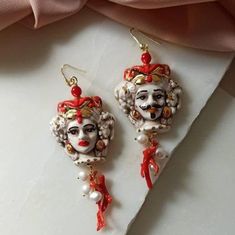 Baroque style earrings made of: - Sicilian handpainted Ceramic heads; - Red Natural Coral branches; - Gold plated 925 Sterling Silver hooks. Lenght : 7,5 cm / 2,96 inches * SHIPPING * Your order will be shipped within 1-3 business days from your purchase. You can choose between 2 shipping methods: STANDARD MAIL (NOT TRACEABLE) It is a cheap and fast shipping method, but NOT TRACEABLE. Chapeau Atelier is not responsible for any postal disruptions, delays or losses. REGISTERED MAIL (TRACEABLE) It Ornate Red Dangle Earrings, Ornate Red Earrings For Party, Handmade Red Chandelier Earrings Gift, Red Hand-painted Dangle Earrings, Red Hand Painted Dangle Earrings, Red Hand Painted Drop Earrings, Red Hand Painted Earrings For Gift, Elegant Hand Painted Jewelry For Party, Red Hand-painted Dangle Jewelry