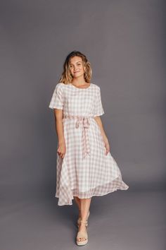 The Clemmie Plaid dress has a beautiful pink plaid pattern. It features a zipper in the back and a tie around the waist. Perfect for all your summer activities. Model is 5’5″ and wearing a Small 100% Polyester  Small: Bust  36″ Length  43″ Medium: Bust  38″ Length  44″ Large: Bust  40″ Length  45″ Casual Gingham Dress With Tie Back, Casual Tie Back Dress For Picnic, Pink Tie Waist Dress For Daywear, Casual Pink Plaid Dress With Short Sleeves, Spring Plaid Sundress, Short Sleeve Pink Dress With Tie Back, Pink Short Sleeve Dress With Tie Back, Pink Knee-length Dresses With Tie Waist, Fitted Gingham Dress With Tie Back