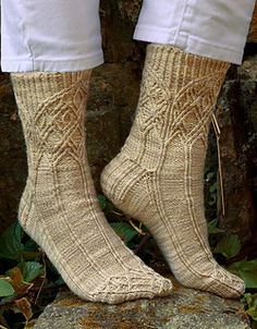 a person standing on top of a rock with their feet up wearing knitted socks