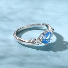 This sterling silver ring, adorned with the essence of the ocean, captures the essence of tranquility and majesty. At its heart lies an ocean blue pear-shaped stone, shimmering with a subtle wave pattern. This unique cut stone appears to be a frozen wave, capturing the essence of the sea's movement in a single moment. The ring's design is inspired by the undulating waves that lap against the shore, each curve and contour mimicking the graceful dance of the sea. The sterling silver band is sleek Fine Jewelry Blue Topaz Teardrop Rings, Elegant Teardrop Topaz Gemstone Ring, Elegant Sterling Silver Pear-shaped Topaz Ring, Elegant Pear-shaped Topaz Ring In Sterling Silver, Elegant Pear-shaped Topaz Ring For Gift, Teardrop Blue Topaz Ring Gift, Elegant Blue Teardrop Topaz Ring, Elegant Silver Pear-shaped Topaz Ring, Elegant Pear Shaped Topaz Ring