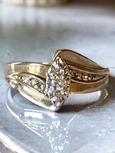 two gold wedding rings sitting on top of a white marble slab with diamonds in the middle