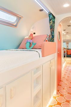 there is a bed in the room with pink and blue decor on it, along with other items