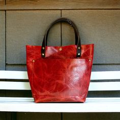 These beautiful totes are one of a kind timeless classics. They are all made with 100% genuine leather ranging from 3-5 oz. All exterior seams are double stitched. This adorable bag measures approx. 10 1/2" tall, approx. 12 1/2" across the top, approx. and has a depth of approx. 5".  The handles have an approx. drop of 7". You can pick to have handles or no handles, snap or no snap, handle color and fastener color. I do not include the cross-body strap.  I use real leather for all my items, whic Red Leather Satchel With Leather Handles, Classic Red Satchel With Leather Handles, Red Rectangular Satchel With Leather Lining, Red Leather Satchel With Leather Lining, Red Double Handle Satchel With Leather Lining, Red Leather Bags For Errands, Classic Red Leather Satchel, Red Leather-lined Double Handle Satchel, Red Rectangular Bag With Leather Lining