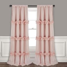 pink ruffled curtains hanging in front of a window