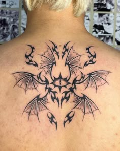 the back of a woman's neck with an intricate tattoo design on her shoulder