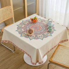 a table with a white table cloth on it and some chairs in front of it